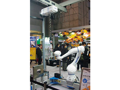 【写真②】「キトー電動チェーンバランサ×ロボットコラボレーション」のデモ。電動チェーンバランサが荷重を支えてくれるので、小さなロボットでも重量物の搬送が可能となる